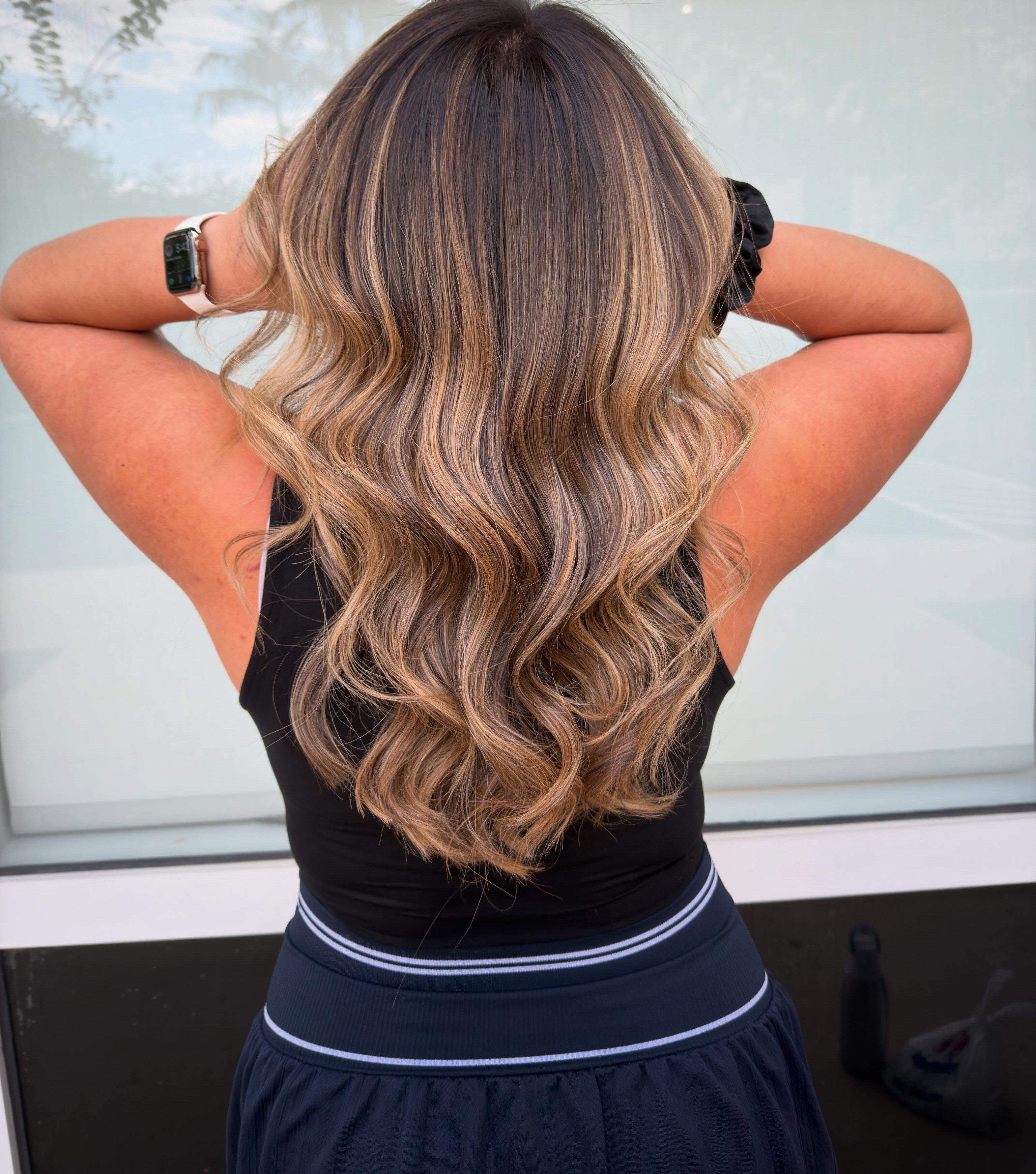Seamless dimensional blonde balayage in loose waves, from a deep root to bright ends