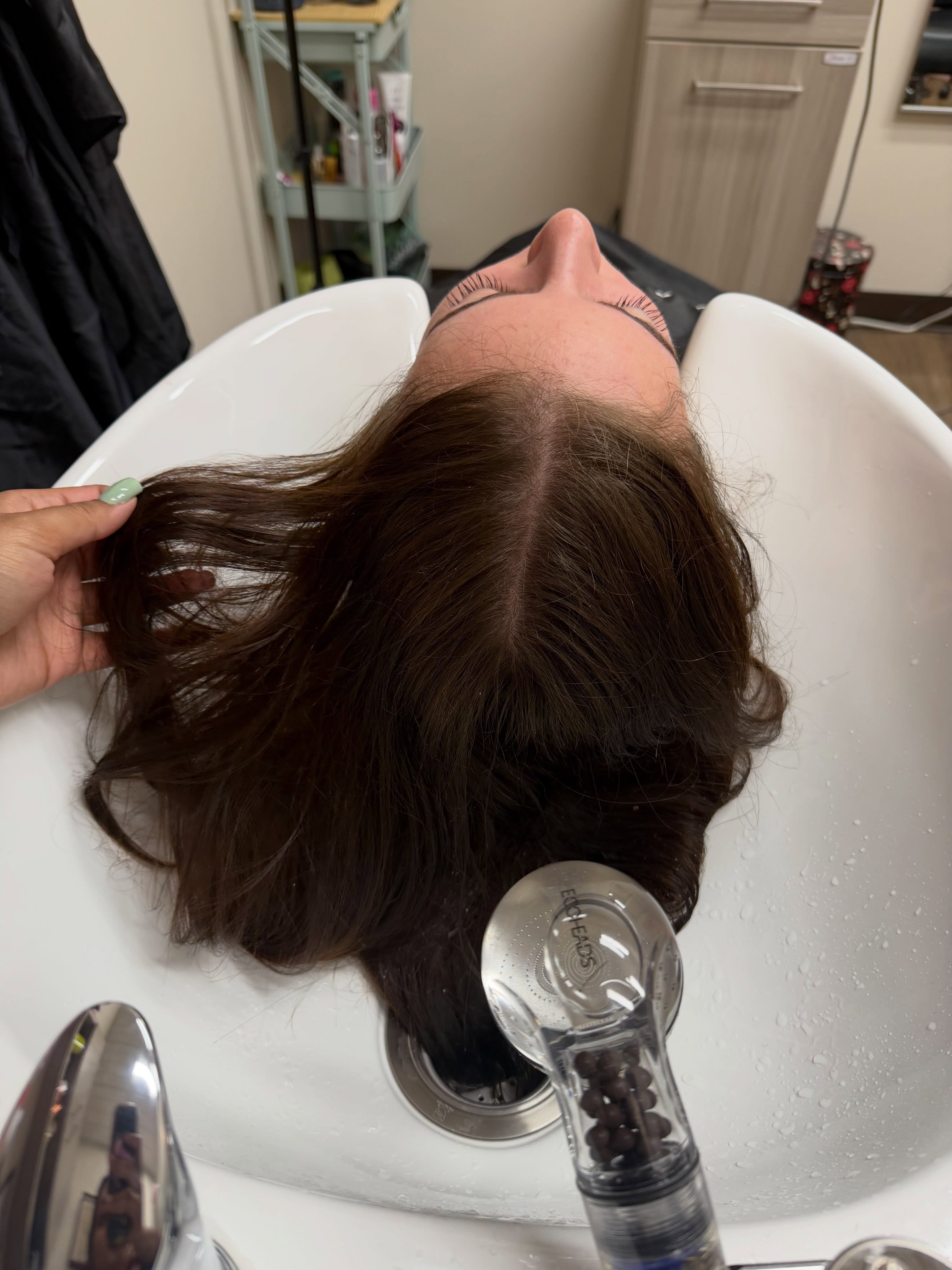 A deep treatment being rinsed through at the shampoo bowl